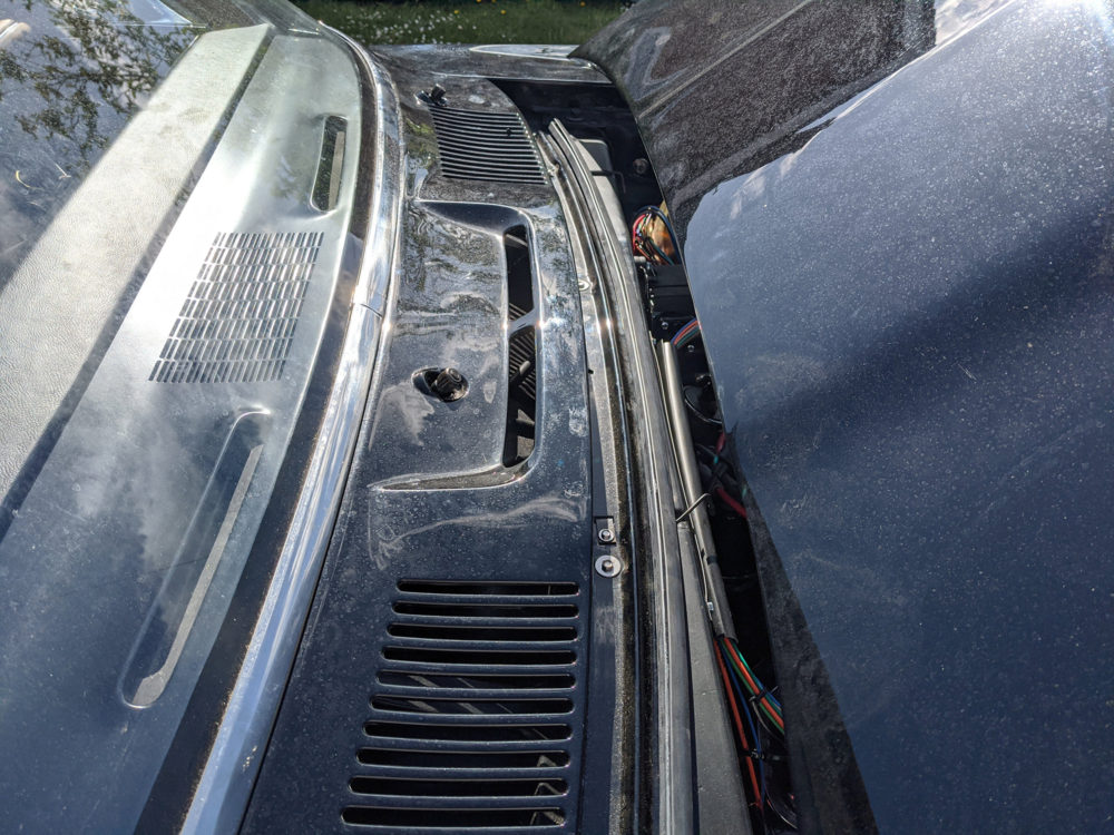 The cowl panel on the car with the wiper studs poking through