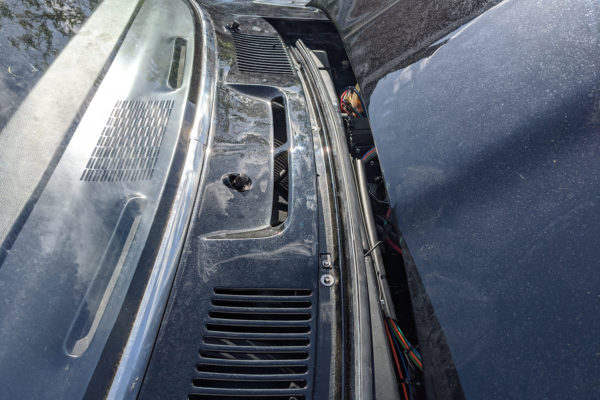 The cowl panel on the car with the wiper studs poking through